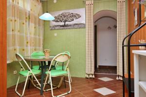 comedor con mesa y sillas verdes en Apartments with a parking space Silo, Krk - 18735, en Šilo