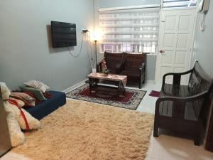 Ria Homestay & kolam في ألور سيتار: غرفة معيشة مع أريكة زرقاء وطاولة