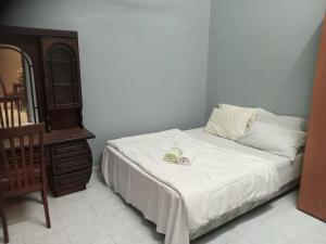 um quarto com uma cama com duas toalhas em Ria Homestay & kolam em Alor Setar