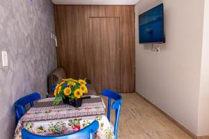 a room with a table with a vase of flowers on it at Apartamento próximo centro in Lages