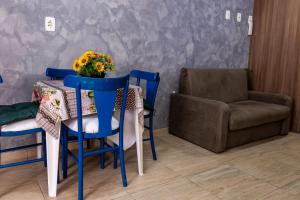 stół i krzesła z wazonem kwiatów w obiekcie Apartamento próximo centro w mieście Lages