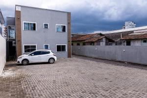 un coche blanco estacionado frente a un edificio en Apartamento próximo centro, en Lages