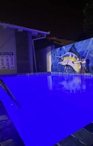 a swimming pool at night with a shark sign on it at Hotel Pousada Sol Nascente in Mafra