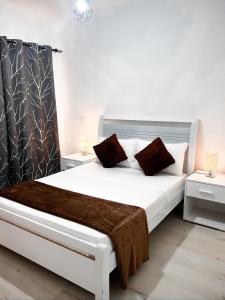 um quarto com uma grande cama branca com almofadas vermelhas em P&SApartments em Santa Maria