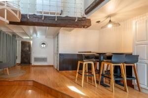 a living room with a bar with stools at LE PAQUIER T3 - à deux pas du lac in Annecy