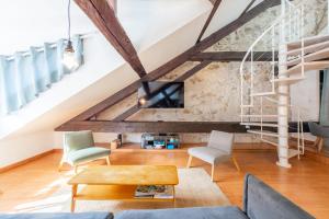 an attic living room with a stone wall at LE PAQUIER T3 - à deux pas du lac in Annecy +26 photos