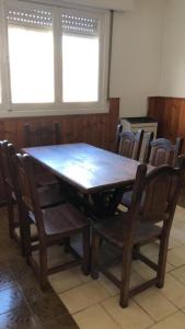 a wooden table and chairs in a room at Cómodo Departamento Hogareño in San Carlos de Bariloche