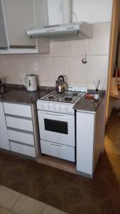 a kitchen with a white stove and a sink at Cómodo Departamento Hogareño in San Carlos de Bariloche