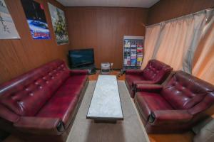 a living room with two leather couches and a television at 貸切民泊勝山ベース325 福井県立恐竜博物館まで車で5分 
