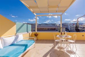 a balcony with a bed and a table and chairs at Fantasia double apartments by the sea Rethymno in Rethymno Town