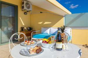 a table with two plates of food and a bottle of wine at Fantasia double apartments by the sea Rethymno in Rethymno Town