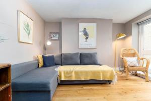 - un salon avec un canapé bleu et un lit dans l'établissement Garden apartment by the sea, à Brighton et Hove