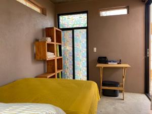 1 dormitorio con cama, mesa y ventana en Casa Tortolita, en Mazunte