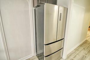 a stainless steel refrigerator in the corner of a room at Beautiful room with private powder room in Vaughan