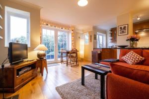a living room with a couch and a tv at Quiet & calm apartment with garden in Brighton & Hove