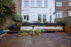 a garden in front of a house with a bench at Quiet & calm apartment with garden in Brighton & Hove