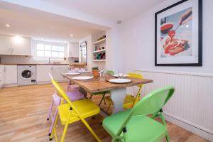 cocina y comedor con mesa de madera y sillas en Quirky Town House With Garden Near The Seafront, en Brighton & Hove