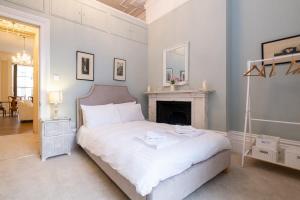 a bedroom with a white bed and a fireplace at Contemporary Regency Balcony Apartment By The Sea! in Brighton & Hove