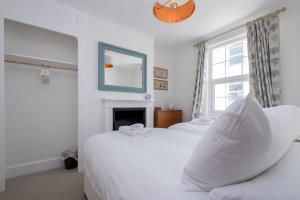 2 Betten in einem Schlafzimmer mit einem Spiegel und einem Kamin in der Unterkunft Lovely 2-bed Cottage in the heart of Kemptown in Brighton & Hove