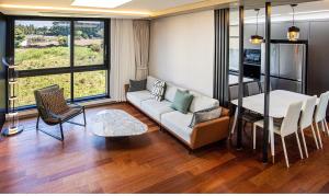 a living room with a couch and a table and chairs at Nobhillstay Jeju in Jeju