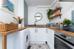 a white kitchen with a washer and dryer at Bright and Beautiful studio apt with king size bed in Brighton & Hove