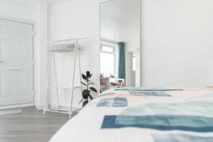 um quarto branco com uma cama e um espelho em Bright and Beautiful studio apt with king size bed em Brighton & Hove