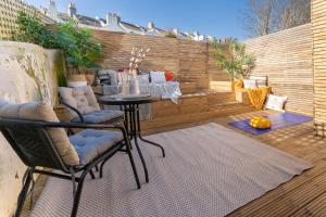 een patio met een tafel en stoelen en een hek bij Beautiful bijou & quiet apartment + outdoor living in Brighton & Hove