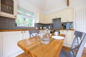 uma cozinha com uma mesa de madeira com copos em Countryside Cottage with Stunning Views em Fletching