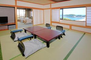sala de estar con mesa, sillas y TV en Resort Hills Toyohama Soranokaze, en Toba
