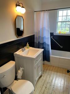 ein Badezimmer mit einem WC, einem Waschbecken und einer Badewanne in der Unterkunft Le Highwater - Cabin in Mansonville