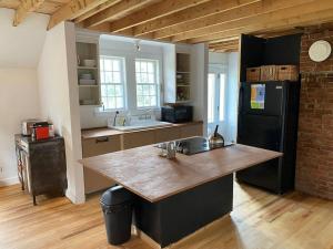 a kitchen with a counter and a black refrigerator at Le Highwater - Cabin in Mansonville