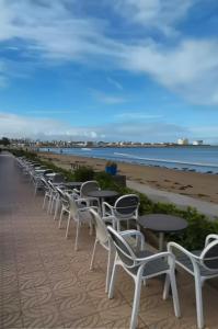 - une rangée de tables et de chaises sur la plage dans l'établissement Résidence BAYTI, à El Jadida