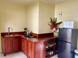 a kitchen with wooden cabinets and a stainless steel refrigerator at Lapita Beach Aore Island Vanuatu in Luganville