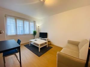 a living room with a couch and a table at Appartement Confortable - Trignac Centre Ville in Trignac