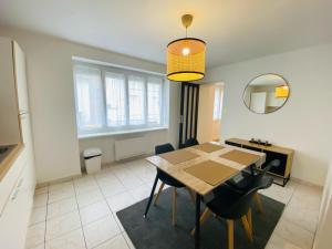 una sala da pranzo con tavolo, sedie e specchio di Appartement Confortable - Trignac Centre Ville a Trignac