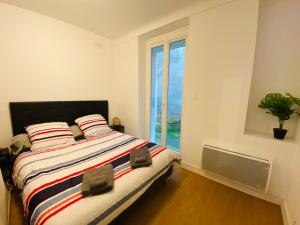 um quarto com uma cama grande e uma janela em Appartement Confortable - Trignac Centre Ville em Trignac