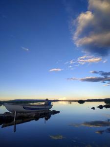 a boat sitting on a dock in the water at Uros Suyawi Titicaca Lodge in Puno