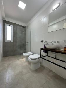 Un baño blanco con inodoro y lavabo. en Alquiler Vivienda Completa en Barrio Residencial, en Buena Nueva