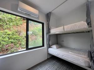 a small room with a bunk bed and a window at LiLa Inn & Motorbike Tours Ha Giang in Ha Giang