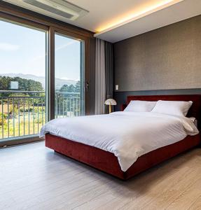 a bedroom with a large bed and a large window at Nobhillstay Jeju in Jeju