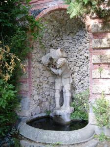 a statue of a person leaning against a stone wall at Fattoria Gambaro di Petrognano in Collodi