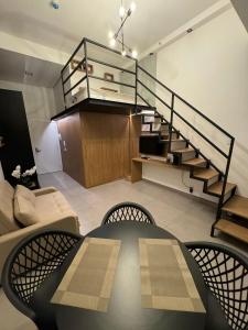 ein Wohnzimmer mit einer Treppe und einer Couch in der Unterkunft 509 | Studio exclusivo Rua Oscar Freire in São Paulo
