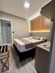 a small bedroom with a bed and a desk at Hotel Lorimar in Penha