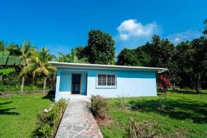 una pequeña casa azul y blanca en un campo en Casa Luna Azul, en La Ceiba