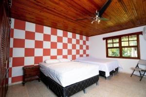 a bedroom with two beds and a checkered wall at Casa Luna Azul in La Ceiba