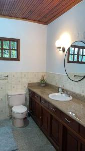 a bathroom with a toilet and a sink and a mirror at Casa Luna Azul in La Ceiba