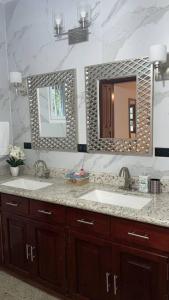 baño con 2 lavabos y espejo grande en Casa Luna Azul, en La Ceiba