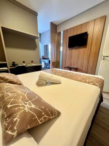 a hotel room with a bed and a television at Hotel Lorimar in Penha