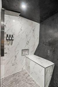 a bathroom with a shower with a marble wall at Dome House YYC, Iconic, Luxury, Backyard Oasis in Calgary