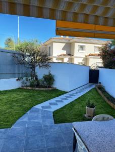 un cortile con una parete bianca e un prato di Villa girasol a Málaga